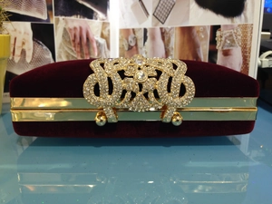 Détail de la pochette de soirée en velours bordeaux avec fermoir couronne en strass