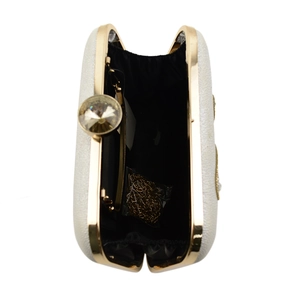 Detail view of the cream crystal clutch bag interior with gold chain strap and gem clasp