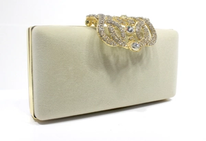 Détail de la pochette de soirée en velours beige avec fermoir couronne en strass de luxe