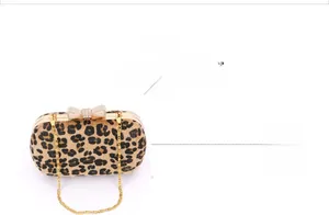 Detail of evening clutch with leopard print fur, diamond bow clasp, and gold chain strap