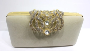 Détail exquis d'une pochette en velours champagne avec fermoir fleuri en strass dorés