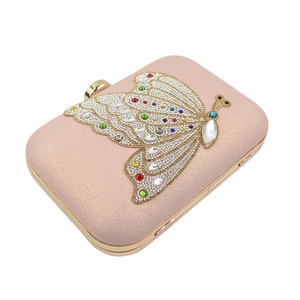 Close-up of sparkling crystal butterfly on a pink pearlescent hard shell evening clutch bag