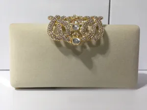 Détail d'une pochette de soirée en velours beige avec boucle de couronne de luxe en strass