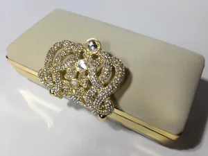Détail d'une pochette de soirée en velours beige avec fermoir couronne en strass dorés