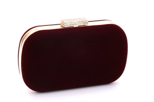 Détail de la pochette de soirée en velours bordeaux avec cadre doré et fermoir strass
