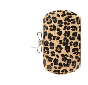 Detailed view of leopard print clutch with rhinestone-studded silver bow metal clasp
