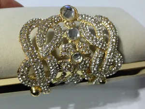 Détail d'un ornement de couronne dorée avec strass sur pochette de soirée en velours