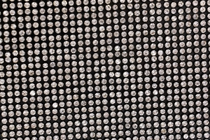 Close-up of sparkling clear rhinestones on black fabric for elegant mermaid evening bag