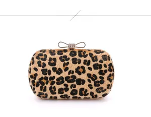 Detail of leopard print evening clutch featuring a gold crystal bow clasp closure