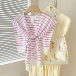 Détail du châle en tricot à rayures violettes et blanches avec nœud au col