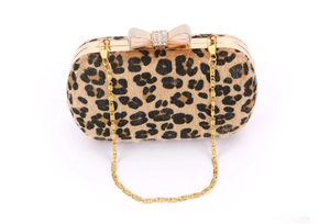 Close-up of leopard print evening clutch with rhinestone bow clasp and gold chain