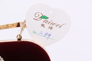Détail du cadre métallique doré et de la doublure en velours rouge de la pochette de soirée