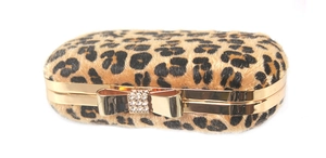 Detail of leopard print clutch with gold bow clasp and sparkling crystal accents