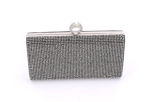 Macro shot of silver rhinestones and ring clasp on black rectangular evening clutch bag