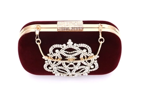Détail macro du sac de soirée en velours bordeaux avec ornements floraux en strass