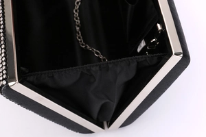 Detail of black evening clutch interior with silver chain strap and rhinestones