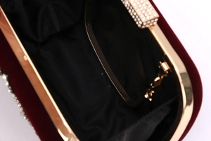 Vue détaillée de l'intérieur d'une pochette en velours bordeaux avec cadre doré et strass