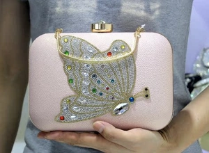 Detail of pink bridal clutch with large crystal butterfly buckle and gold chain strap