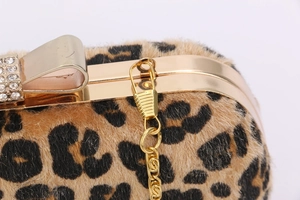 Close-up of leopard faux fur evening bag with gold metal frame and crystal bow clasp