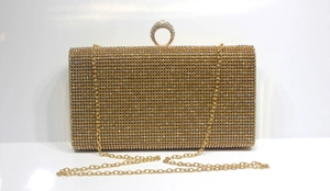 Detail of mermaid crystal evening clutch featuring a luxury diamond ring clasp and gold chain
