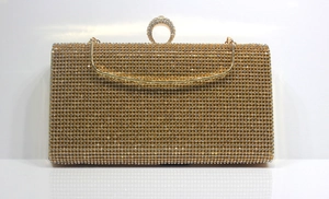 Detailed macro of golden rectangular clutch with sparkling rhinestones and crescent clasp