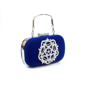 Détail d'une pochette en velours bleu roi avec motifs en strass et poignée argentée