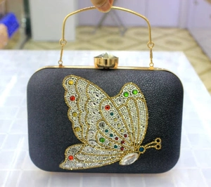 Detail of black clutch bag with colorful rhinestone butterfly and crystal handle clasp