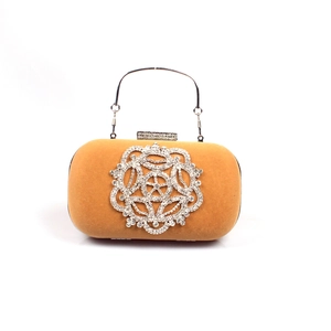 Vue détaillée d'une pochette en velours orange avec motif floral en strass