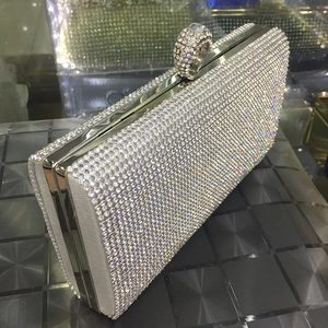Macro detail of silver rectangular clutch bag with encrusted rhinestones and ring clasp