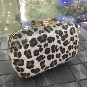 Close-up of leopard print faux fur evening clutch with rhinestone bow clasp and gold frame