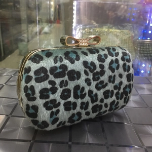 Close-up of blue leopard print faux fur evening bag with sparkling rhinestone bow clasp