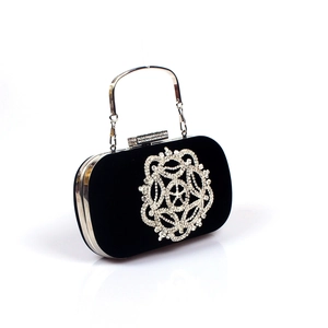 Détail d'une pochette de soirée en velours noir avec ornement en strass et poignée en argent