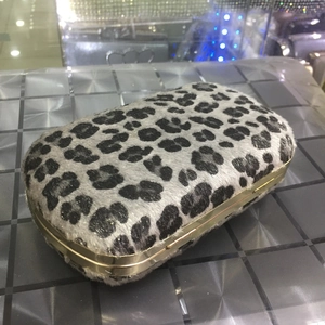 Close-up of leopard print faux fur evening clutch bag with golden metal frame