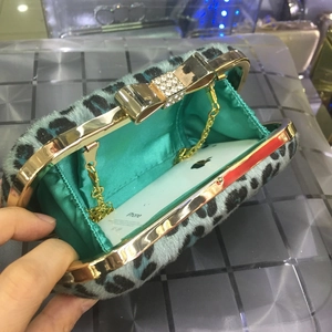 Detail of blue leopard faux fur evening clutch with crystal bow clasp and gold chain strap