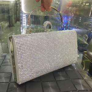 Detailed view of silver evening clutch featuring full rhinestones and ring clasp