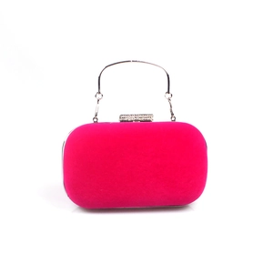 Détail d'une pochette de soirée en velours rose avec fermoir en strass et anse argentée