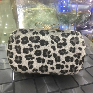Detail of leopard print evening clutch featuring crystal-encrusted gold bow clasp