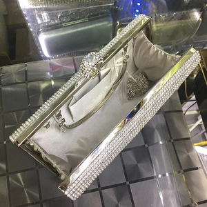 Macro shot of silver rhinestone evening clutch with crystal ball clasp and chain strap