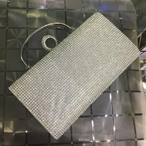 Detail of silver rhinestone clutch bag with sparkling crystals and metal ring handle