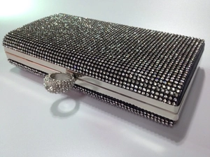 Detailed view of rhinestone-encrusted evening clutch with silver metal ring clasp