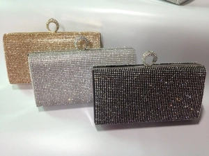 Macro detail of rhinestone evening clutch bags in gold, silver, and black with ring clasps