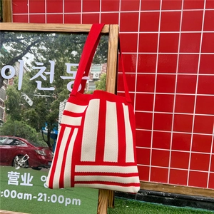 Detail of red and cream striped knitted tote bag with thick textured fabric and shoulder strap