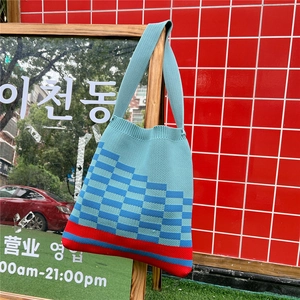 Chic knit tote bag featuring blue checkerboard patterns and a red contrast base