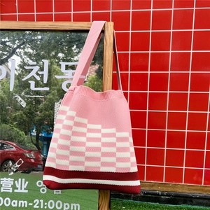 Detail of pink and white checkered knit tote bag showing soft cotton texture and strap