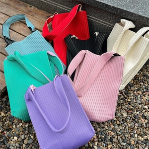 Vertical pleated knit tote bags in various vibrant colors with wide shoulder straps