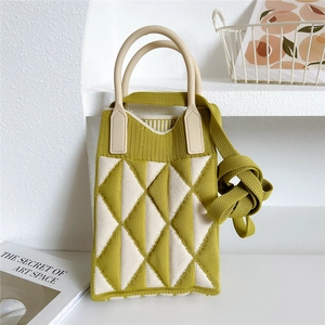 Detail of knitted handbag featuring olive green geometric patterns and soft silicone handles