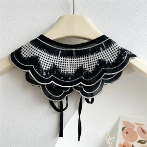 Detail of white lace detachable collar with black sequins and adjustable bow tie