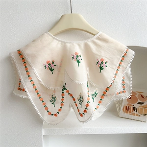 Detailed embroidery on a beige doll-style fake collar with floral patterns and pom-poms