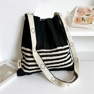 Pleated knit crossbody bag with black and white stripes and minimalist designer shoulder strap