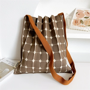 Macro detail of brown checkered knit tote bag with pleated texture and KNSH side label